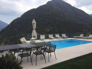 a patio with a table and chairs next to a pool at Villa Lilla in Argegno