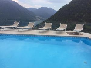 a group of chairs sitting next to a swimming pool at Villa Lilla in Argegno