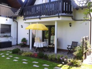 un patio con una mesa y una sombrilla amarilla en Haus Kollwitzweg - Ferienwohnungen, en Goslar