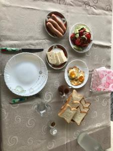 einen Tisch mit Teller mit Essen und Brot darauf in der Unterkunft Season in Kutaissi