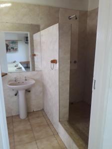 uma casa de banho com um chuveiro e um lavatório. em Lentswe Lodge em Serowe