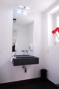 a bathroom with a black sink and a mirror at Villa Lilla in Argegno