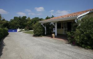 a house with a driveway next to a road at Logis Hôtel Corintel Bordeaux Est in Tresses