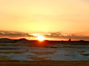 a sunset on the beach with the ocean at Ahmed Safari Camp in Bawati