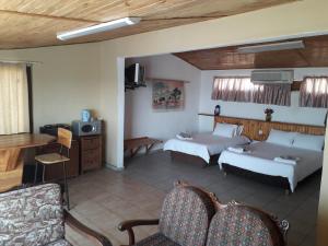 a living room with two beds and a tv at Lentswe Lodge in Serowe