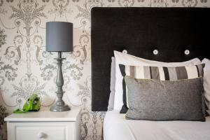 a bedroom with a bed with a lamp on a night stand at Beachlands Hotel in Weston-super-Mare