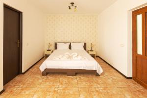 Un dormitorio con una cama con sábanas blancas y flores. en Rosiem House, en Techirghiol