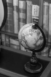 a globe sitting on a table in front of a book shelf at Beachlands Hotel in Weston-super-Mare