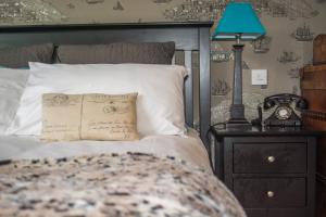a bed with a pillow and a lamp on a night stand at Beachlands Hotel in Weston-super-Mare