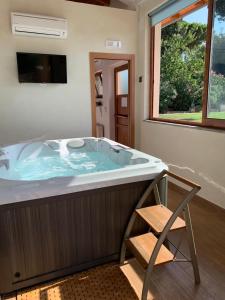 eine große Badewanne mit Stuhl im Bad in der Unterkunft Villa Giuseppe Bernabei Guest House in Marino