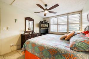 a bedroom with a bed and a ceiling fan at Kamaole Sands in Wailea