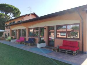 una casa con sedie rosse e blu su un patio di Villa Giuseppe Bernabei Guest House a Marino