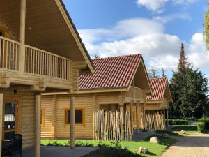 a row of log homes with a fence at Boomstamhuis High Chaparral in Oorsbeek