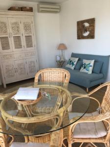 a living room with a table and chairs and a couch at Villa L'Amiraute in Agde