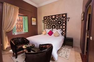 a bedroom with a bed and two chairs at RIAD AZRUR in Marrakech