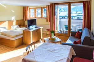 a living room with a bed and a couch and a tv at Appartements Monuth in Bad Hofgastein