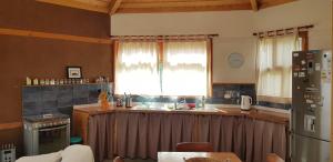 cocina con fregadero y nevera en Las Palmas Lodge en Olmué