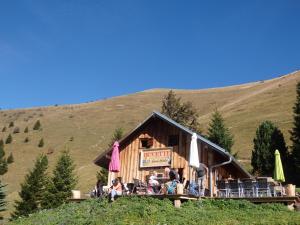 a log restaurant with chairs and umbrellas on a hill at AU COEUR DES ALPES in Marignier