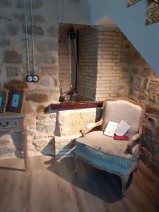 una silla en una habitación con una pared de piedra en VTAR Casa del AOVE, en Baeza
