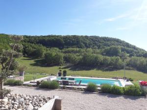 a swimming pool with a hill in the background at GITE LA ROCHE in Le Boulvé