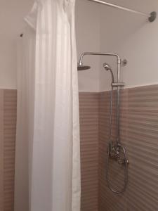 een douche met een wit douchegordijn in de badkamer bij Camere Centrale in Piteşti