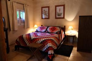 ein Schlafzimmer mit einem Bett mit einer bunten Decke in der Unterkunft Hotel Fazenda São Francisco in Cunha