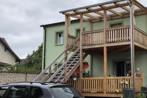 a house with a wooden deck and a car parked in front at Stolpseeblick in Himmelpfort