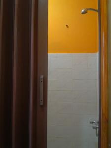 a bathroom with a shower and a white tile wall at Portezuelo del Viento - Hostel de Montaña in Las Cuevas +74 photos