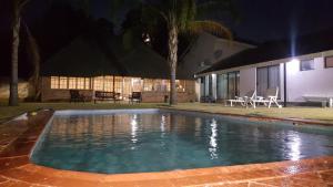 uma piscina em frente a uma casa à noite em Luxury Heights Guesthouse em Newcastle