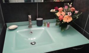 a bathroom sink with a vase of flowers on it at SETE maison de ville avec jardin clos in Sète