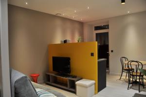 sala de estar con TV y pared amarilla en Le 505, en Saint-Jean-dÊ¼Avelanne