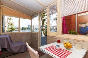 a table with a bowl of bananas on it in a room with windows at Sobe Pegla in Zadar