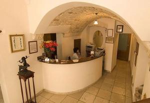 a woman sitting at a counter in a room at Hotel Palazzo D'Erchia in Conversano