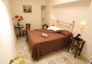 a bedroom with a bed and a table with a plate on it at Hotel Palazzo D'Erchia in Conversano