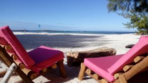 twee stoelen zittend op een strand met de oceaan bij Ocean Lodge Kite & Windsurf in Diego Suarez
