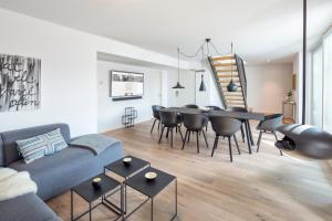 a living room with a couch and a table and chairs at cosy grey apartments in Freiburg im Breisgau +26 photos
