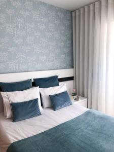 a bedroom with a bed with blue and white pillows at OPORTO House AL in Maia