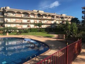um hotel com piscina em frente a um edifício em Golden Beach 208 em Sant Carles de la Ràpita
