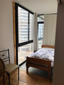 a bedroom with a bed and a large window at Vista al Mar Departamento - Edificio Acapulco in Viña del Mar