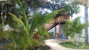 a house with palm trees in front of it at Zamunda Garden View in Tulum