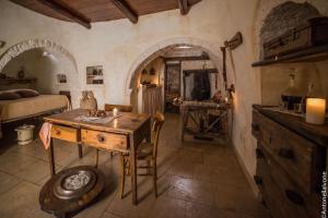 Zimmer mit einem Tisch und einem Bett sowie einer Küche in der Unterkunft Rione Pentimi in Alberobello