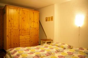 a bedroom with a bed and a wooden cabinet at Ferienwohnung Fesenfeld Bremen Steintorviertel in Bremen