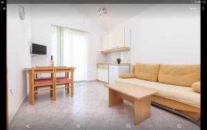 a living room with a couch and a table at Apartmani Villa Mimi in Brodarica