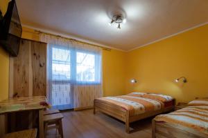 1 dormitorio con 2 camas y ventana en Villa Dam, en Liptovský Mikuláš
