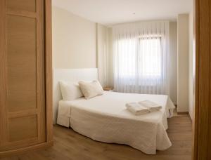 A bed or beds in a room at Apartamento Rosaleda Még 14 kép