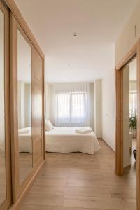 a bedroom with a large mirror and a bed at Apartamento Rosaleda in Melide