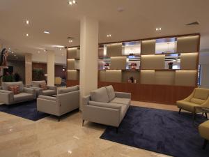 a waiting room with couches and chairs in a lobby at Consolata Hotel in Fátima