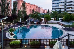 a large swimming pool in the middle of a city at Eurostars Suites Mirasierra in Madrid