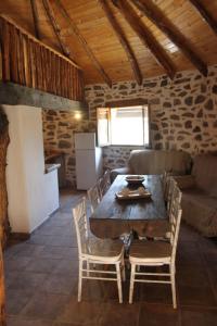cocina y comedor con mesa y sillas en Alojamiento Los Chozos, en Cazalla de la Sierra
