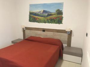 1 dormitorio con 1 cama con una pintura en la pared en Costa Makauda Residence, en Sciacca